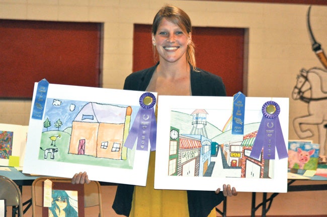 Lana Pouncey, second year art teacher for Lowndes Academy in Lowndesboro, shows off the Best of Show winning art of two of her students Dylan Davis for Level 2-3 and Carmen Till for Level 7-9. The two were among winners at the Alabama Independent School Association’s District 5 Art Show hosted Wednesday at Morgan Academy in Selma.