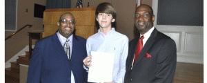 Dr. Aaron D. McCall, managing director of SCABC,  left, and Charlie King Jr., president of the SCABC board of directors, right, join Hooper Academy student Wilson Ellis at a press conference to launch an educational campaign by the SCABC. 