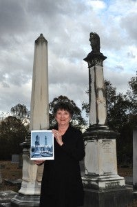 Carolyn Smith Parker shows off her new book "Harbingers of North Lowndes" at Oakview Cemetery in Lowndesboro, which graces its cover. Fred Guarino/Lowndes Signal. 